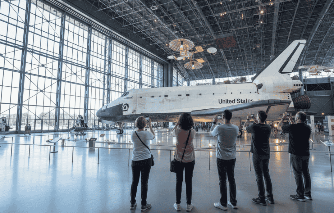 Visitors taking photos of the Space Shuttle Discovery inside the Smithsonian National Air and Space Museum in Washington, DC.