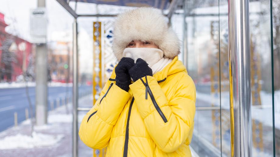 An outdoor subway platform in New York City during winter, capturing a cold and windy atmosphere
