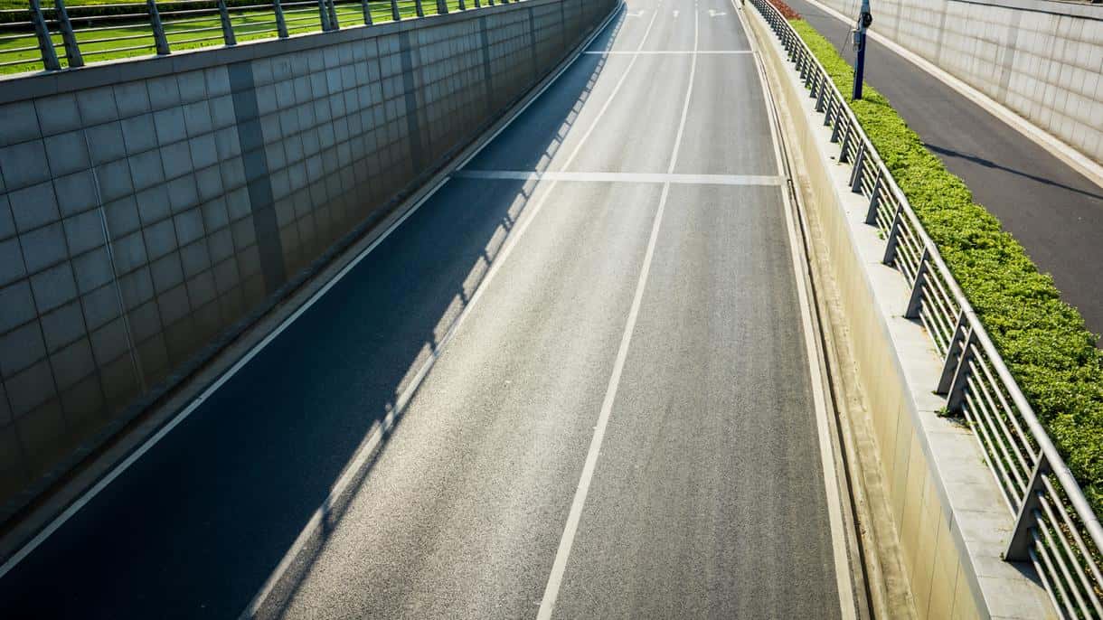 Commercial trucks and cargo vans driving legally on a New York expressway