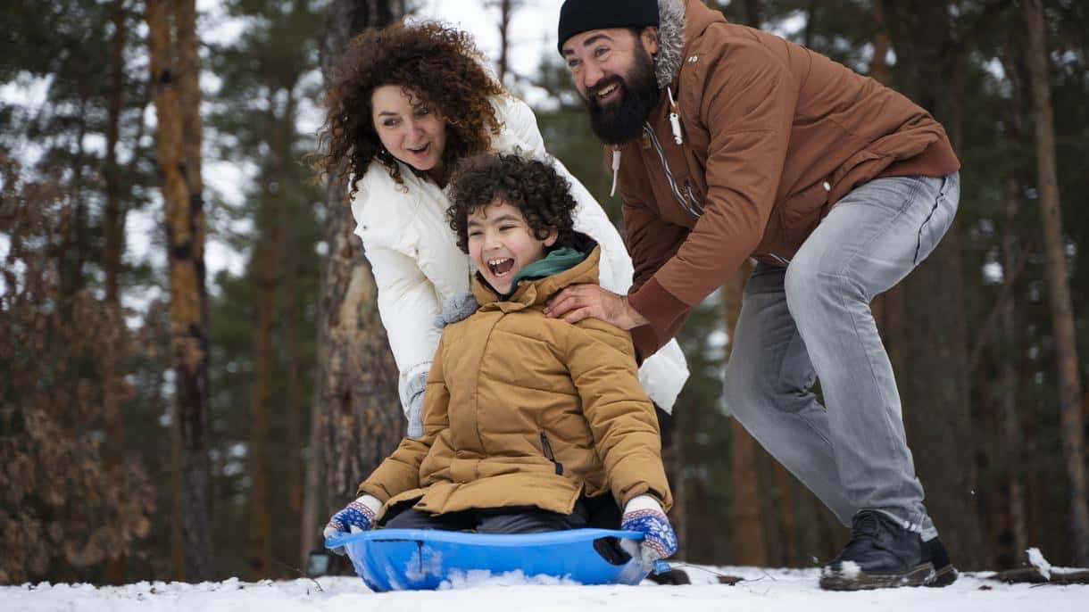 Happy family enjoying snow tubing and beginner skiing at a family-friendly resort like Camelback or Mountain Creek