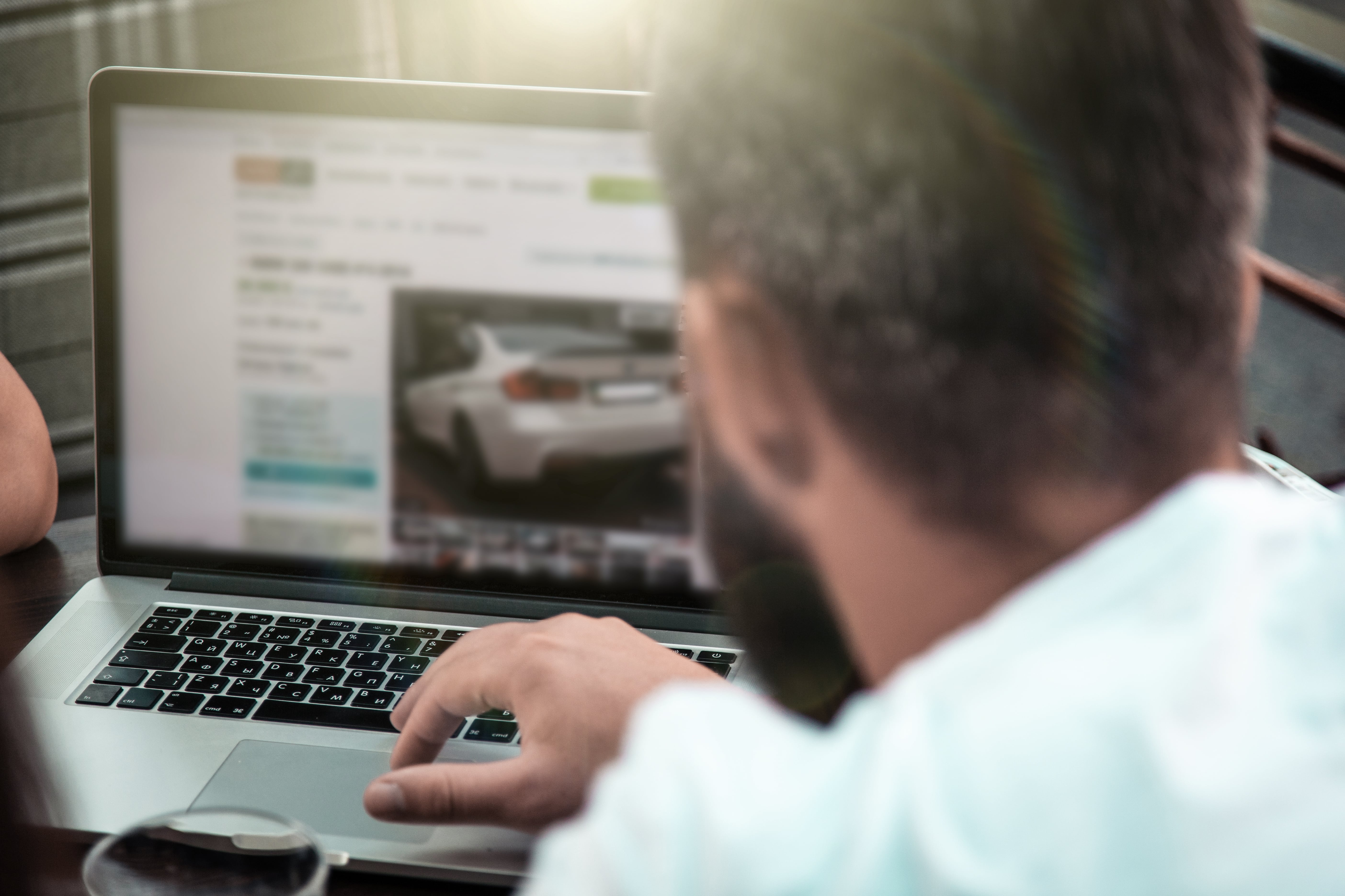 On the left side of the screen is a laptop with a man sitting behind it