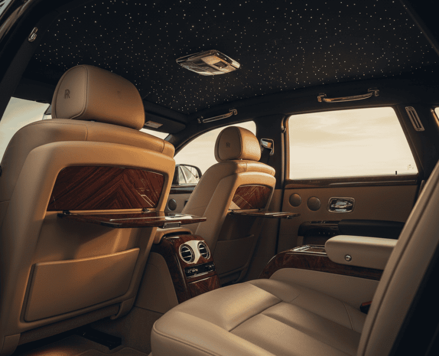 Handcrafted interior of a Rolls-Royce Phantom featuring leather seats, wood accents, and a starlight headliner for luxury comfort