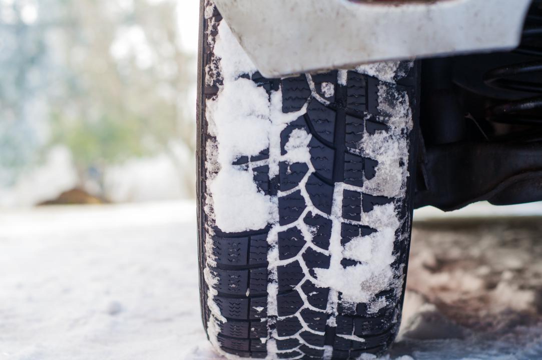 Closeup of a winter tire with M+S and 3PMSF symbols showing deep tread for safe driving on snow and ice