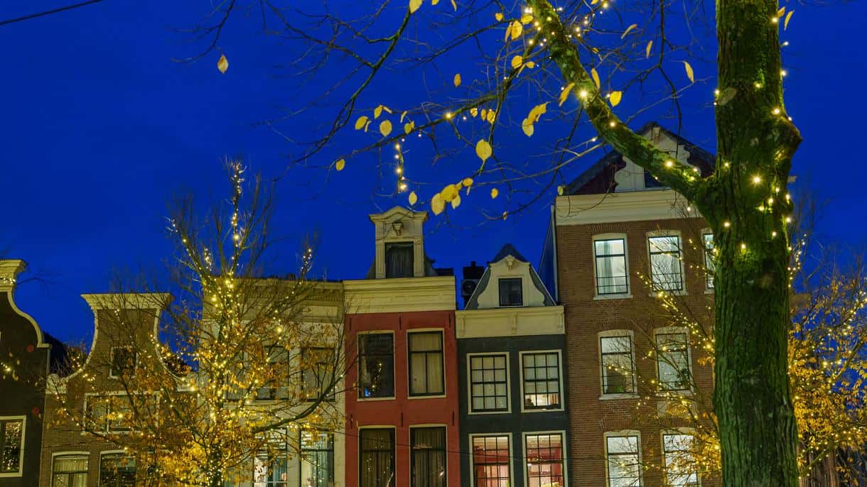 Evening street with European-style houses decorated with warm Christmas lights on trees