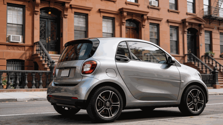 A modern compact rental car parked on a narrow street in New York City.