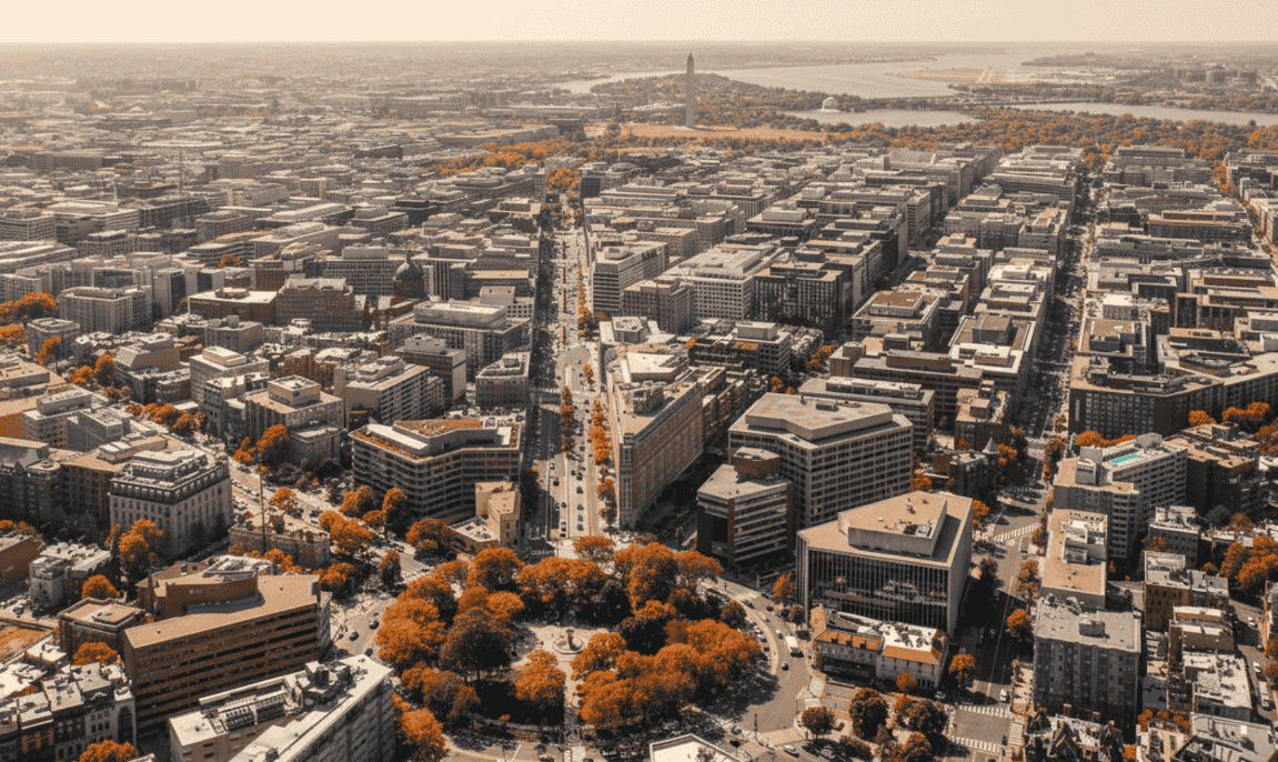 Aerial view of the Washington, DC cityscape during the fall, showing the city grid and the Washington Monument in the distance.